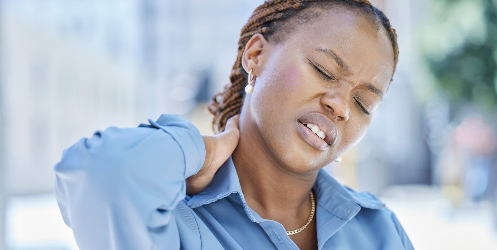 Woman manager with stress and pain in her neck while standing outside the office building. Female b.